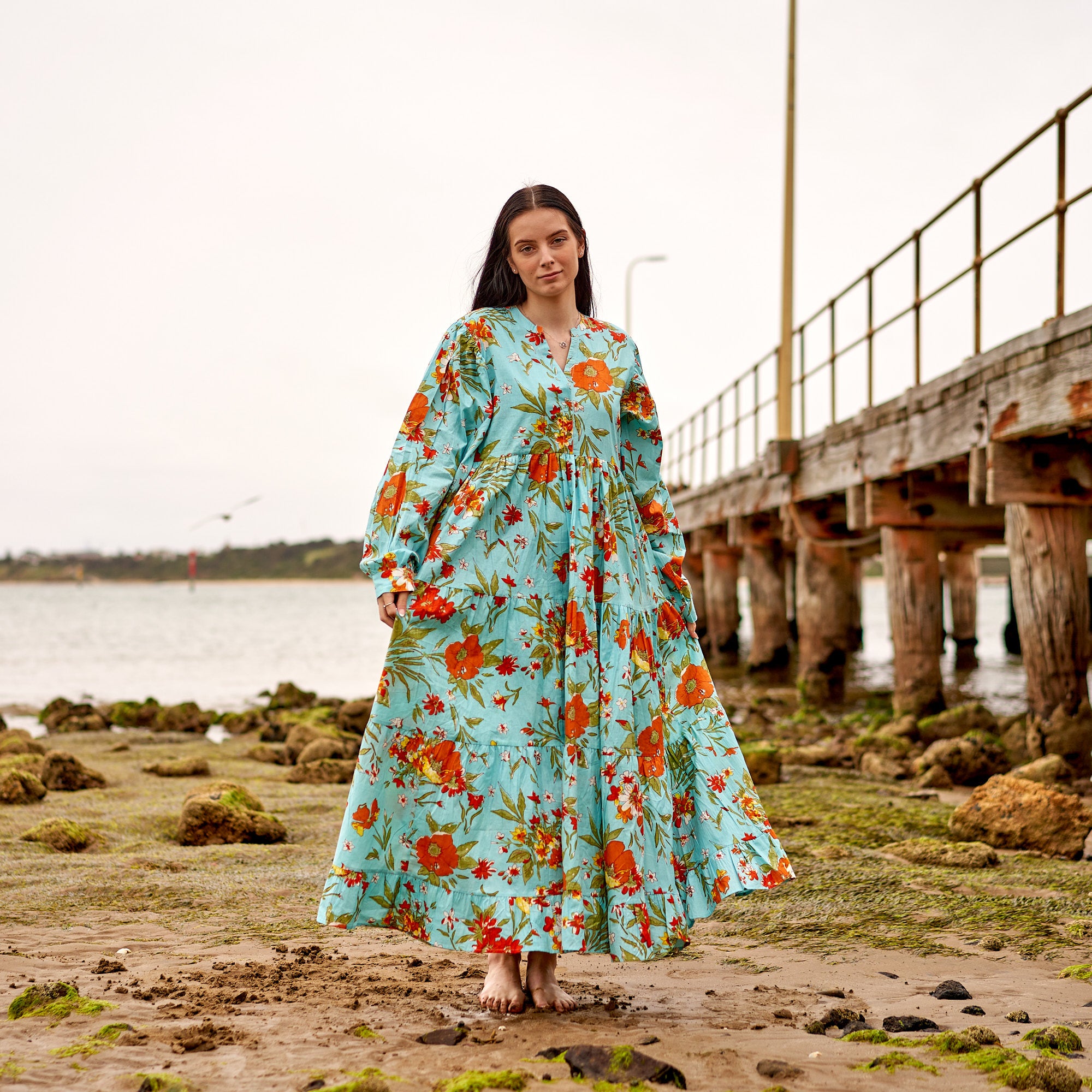 Lightweight cotton maxi dress with long sleeves, floral boho outfit for warm weather.
Tiered blue floral maxi dress in breathable cotton, casual chic summer look.