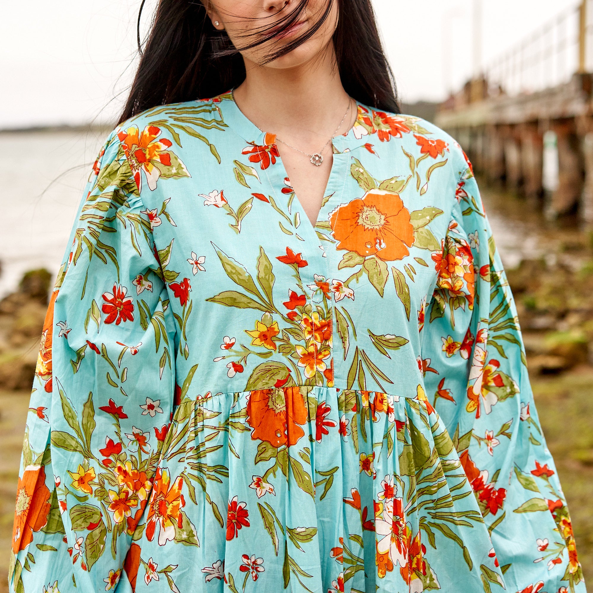 Handcrafted cotton boho dress with vibrant blue floral design, resort wear style.
Flowy blue floral maxi dress, perfect beach holiday outfit for women.