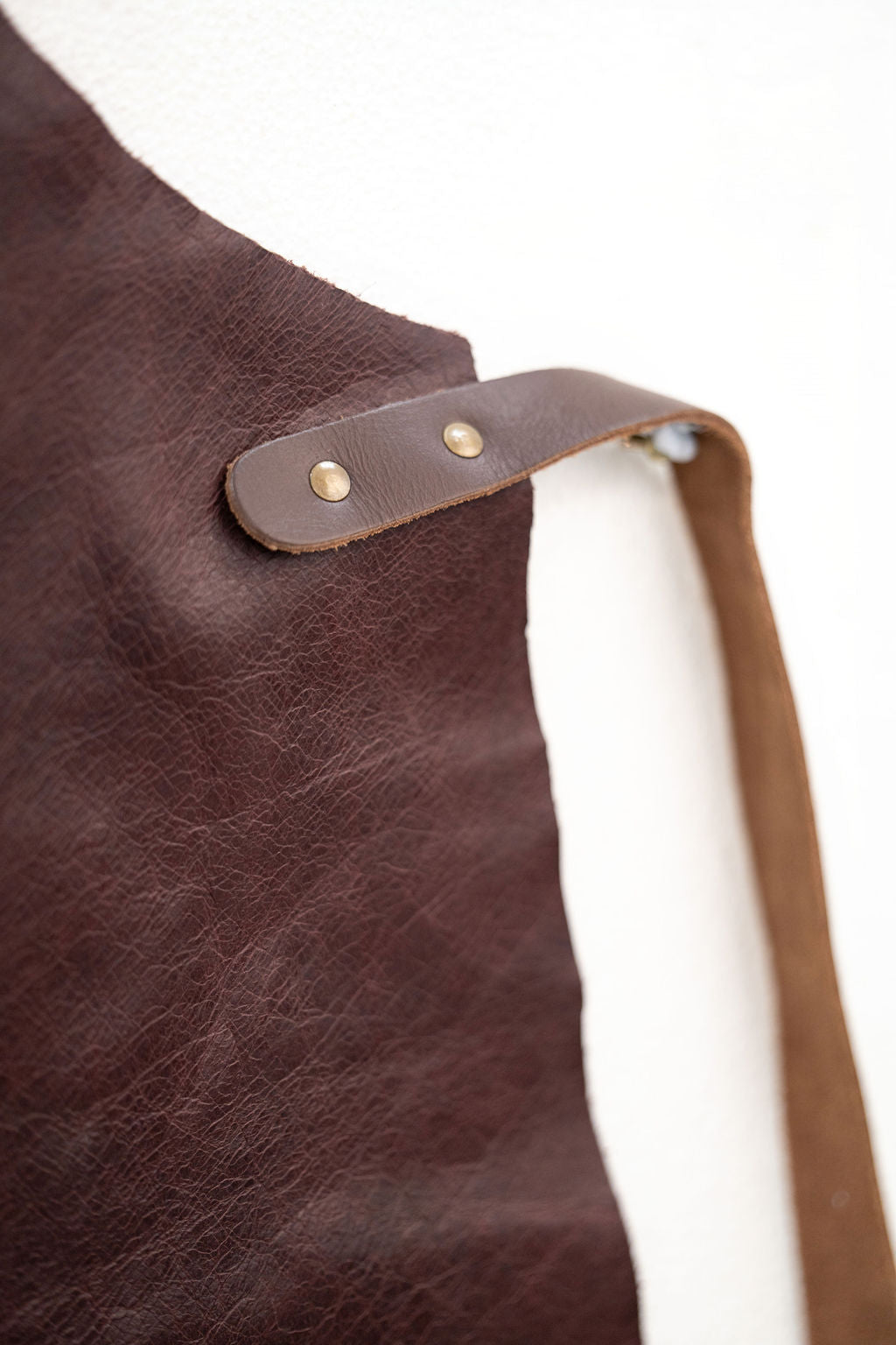 Close-up of espresso brown leather apron showing rich texture detail
