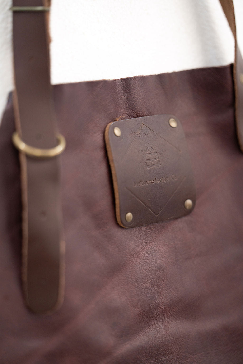 Back view of espresso brown leather apron with cross adjustable straps