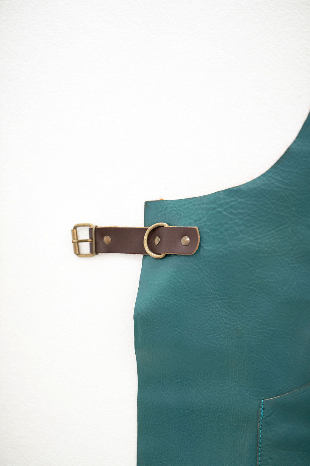 Close-up of ocean teal leather apron showing premium texture detail