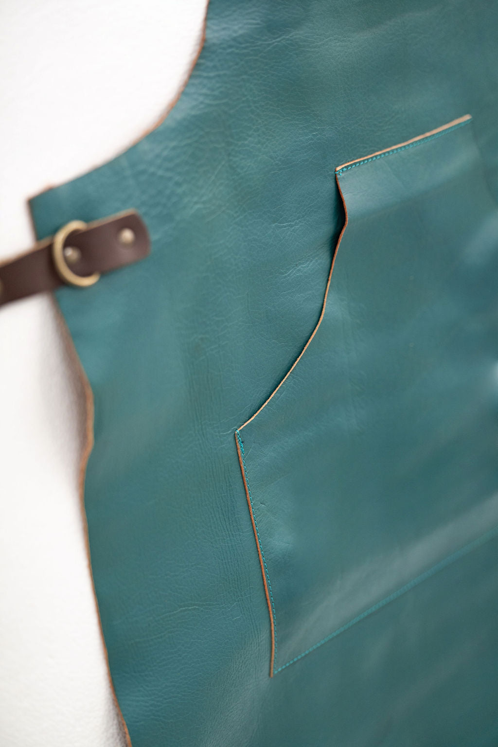 Back view of ocean teal leather apron with cross adjustable straps