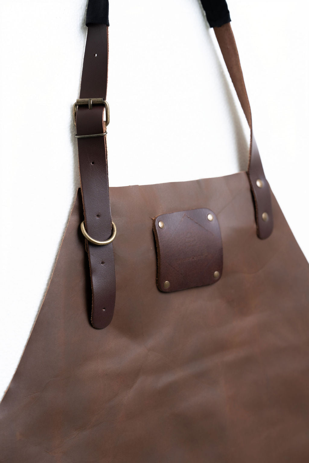 Heavy-duty brown leather work apron with adjustable fit and long length