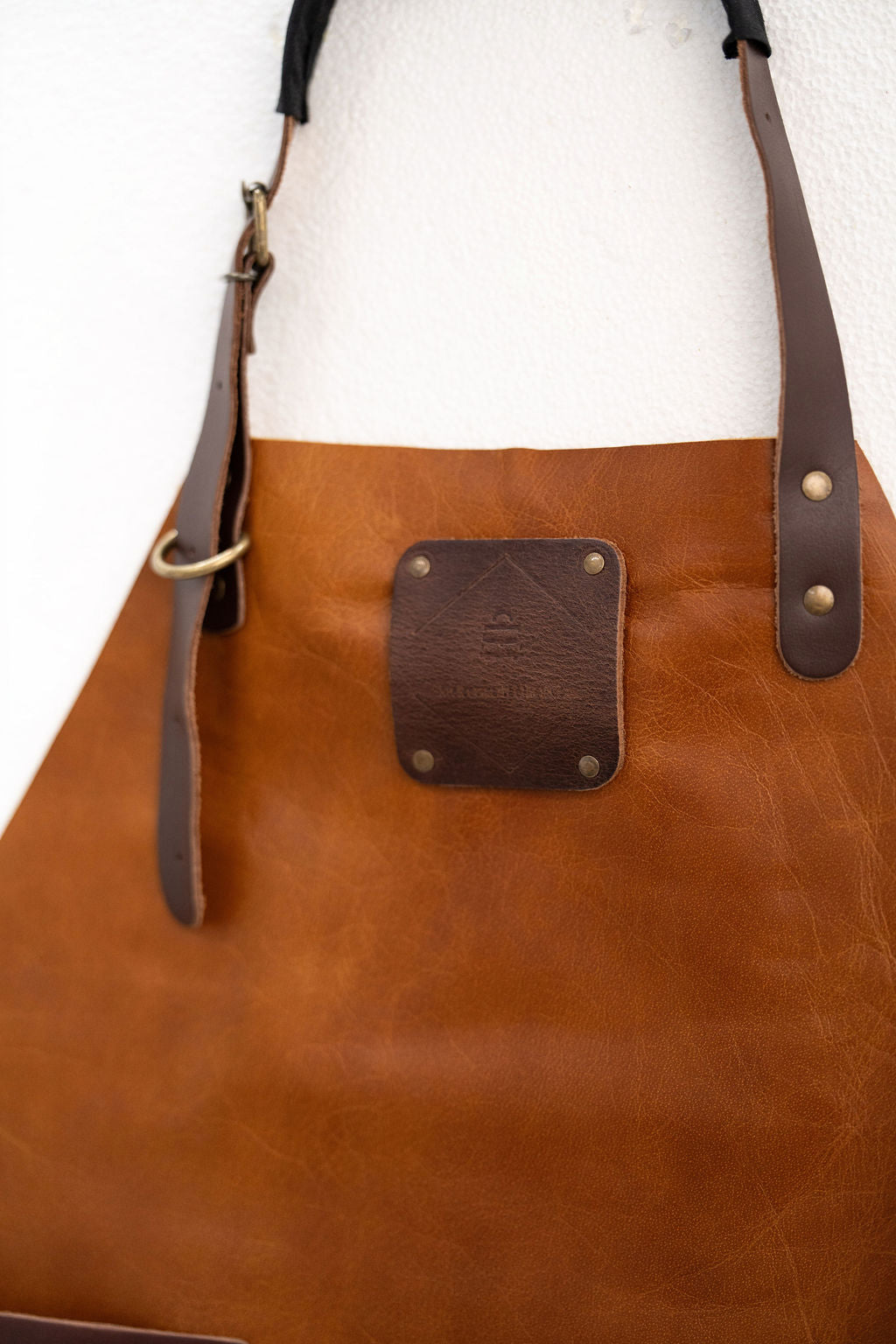 Close-up of saddle brown leather apron showing premium texture detail
