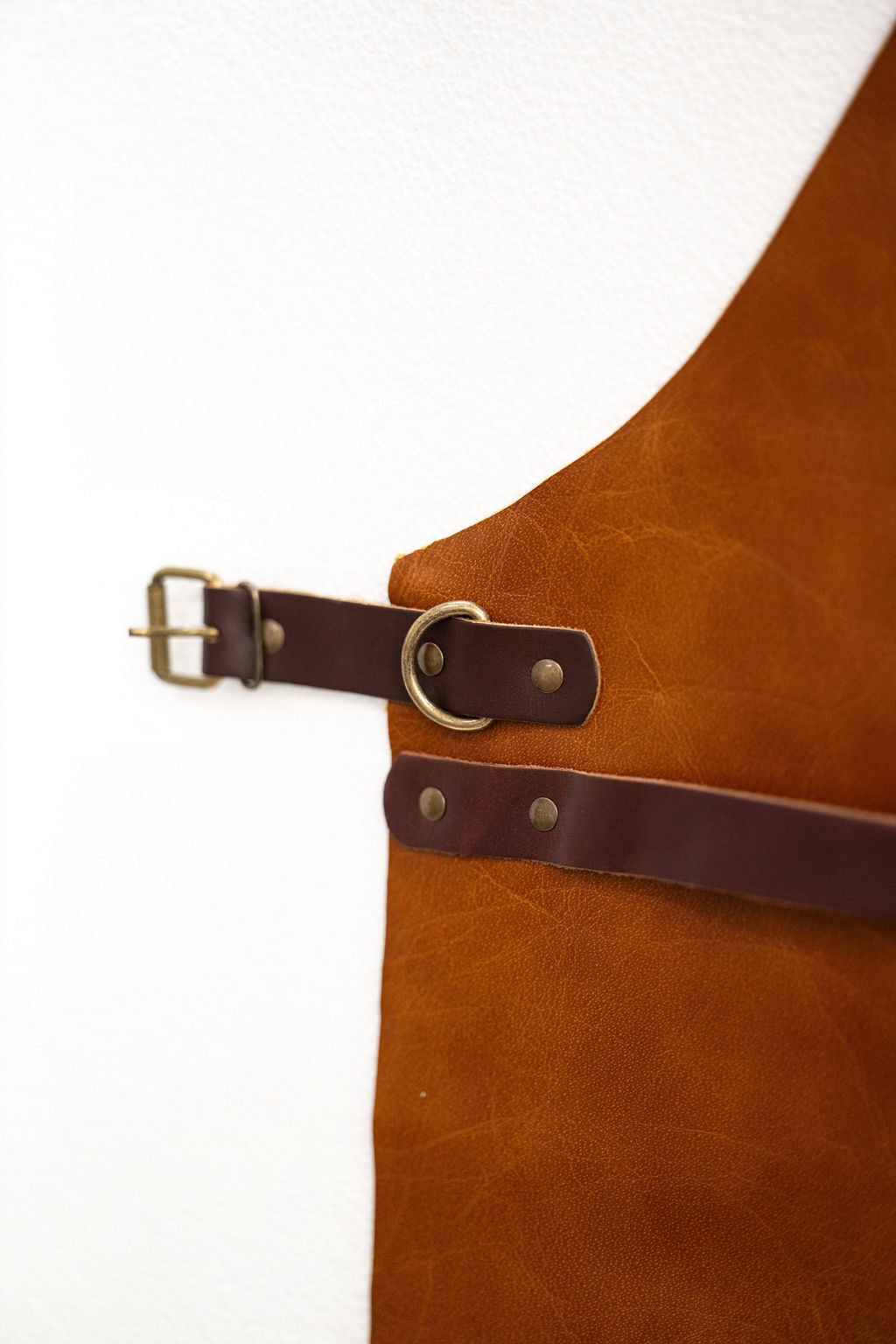 Back view of vintage saddle brown leather apron with cross straps