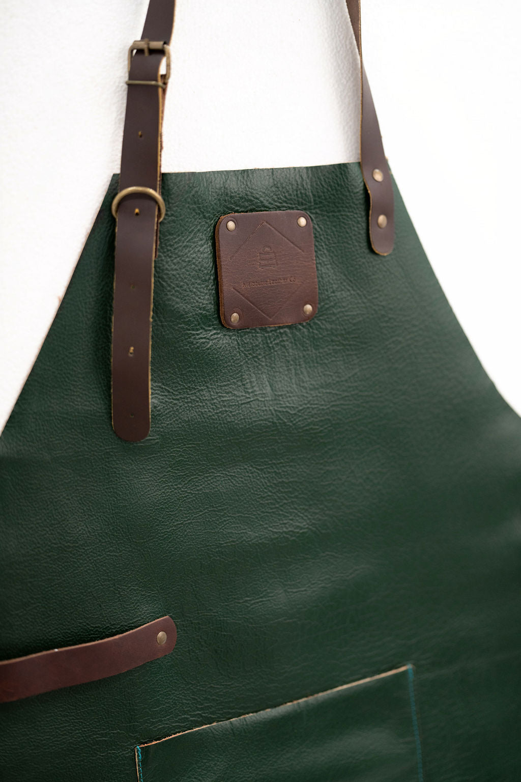 Stylish forest green leather apron with adjustable straps for professionals