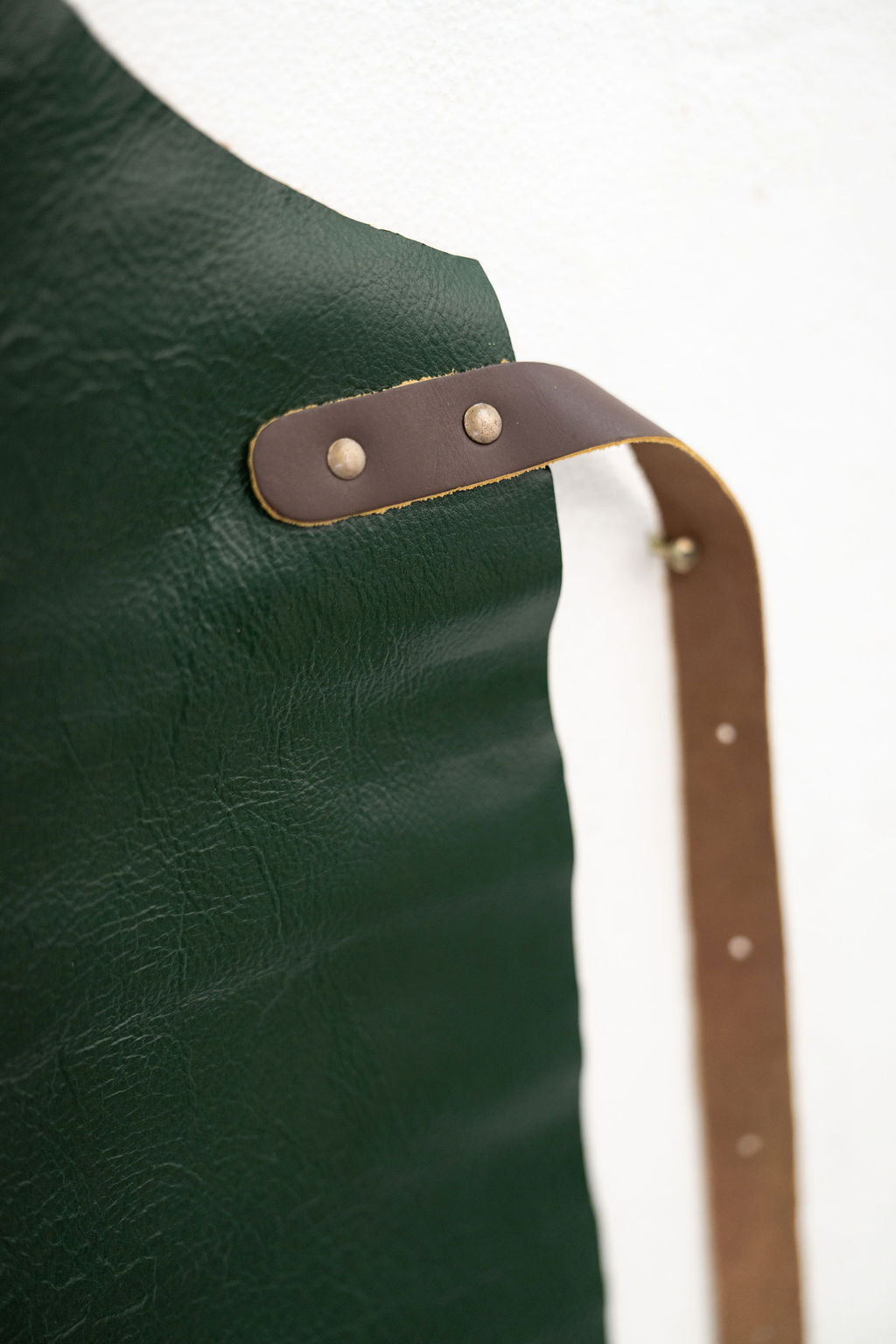 Professional forest green leather apron worn in workshop environment