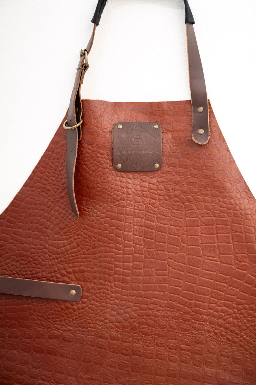 Croc embossed leather apron close-up showing textured pattern detail
