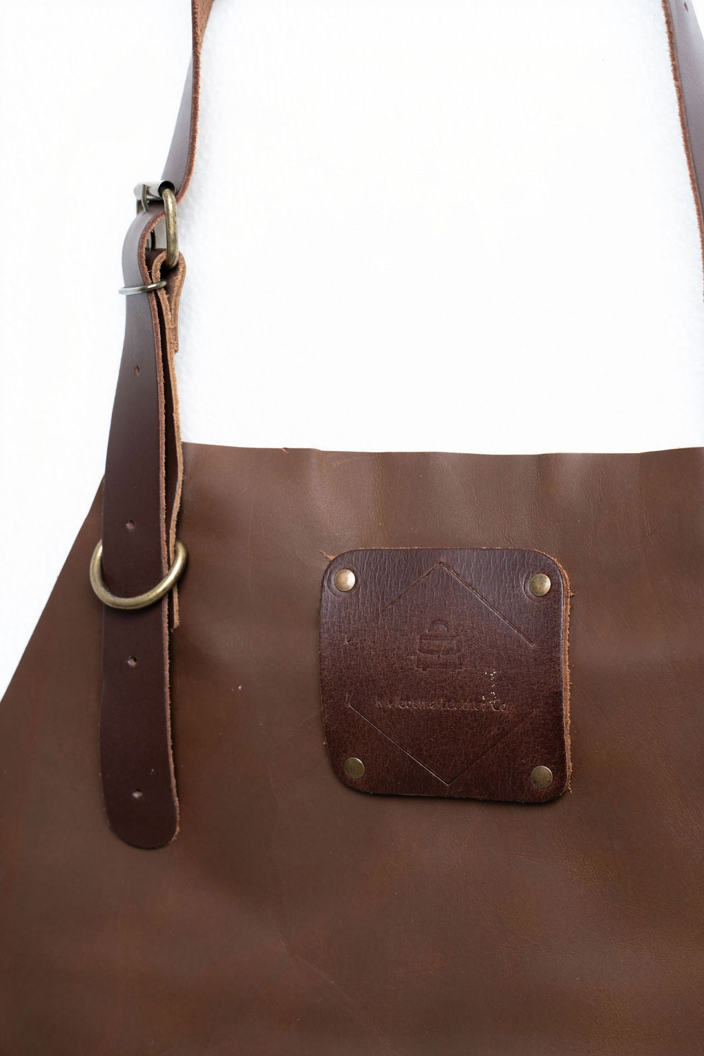 Brown leather apron with adjustable straps close-up premium texture detail
