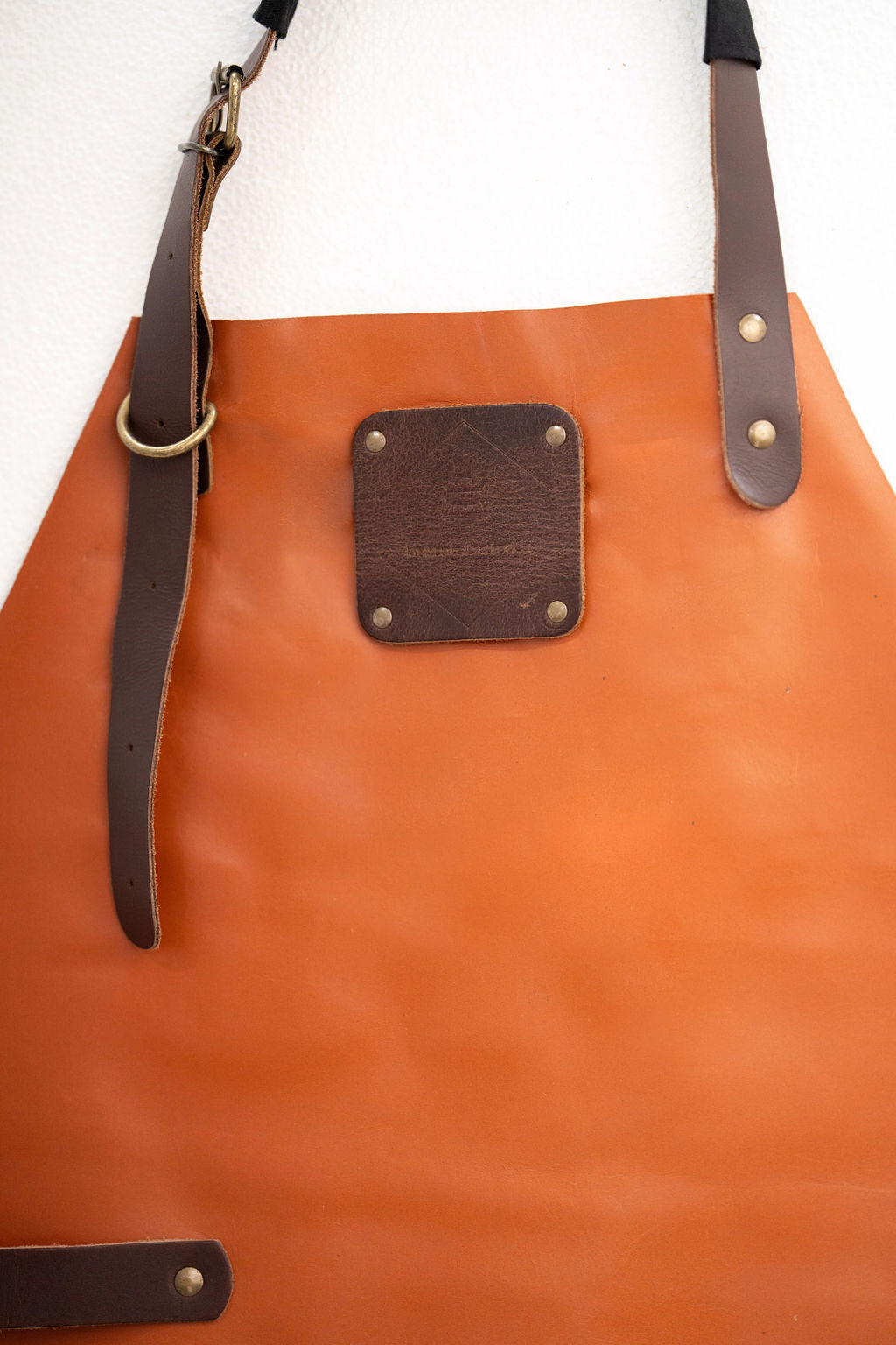 Close-up of cognac leather apron showing rich texture and finish