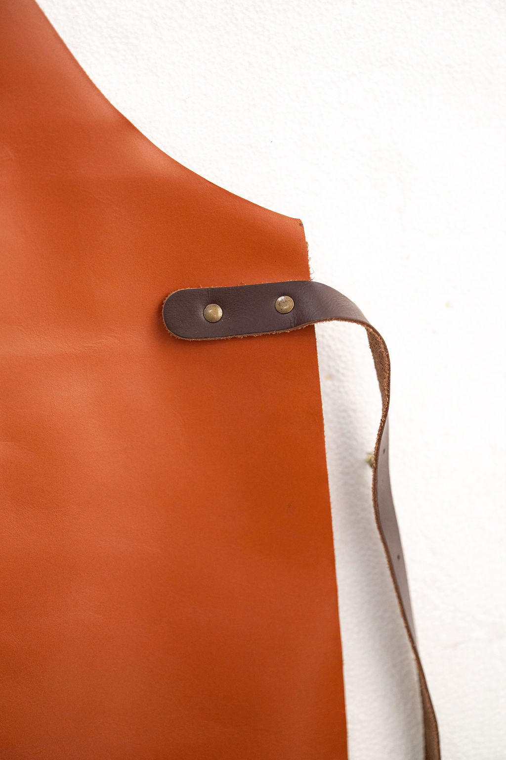 Back view of cognac tan leather apron with adjustable cross straps