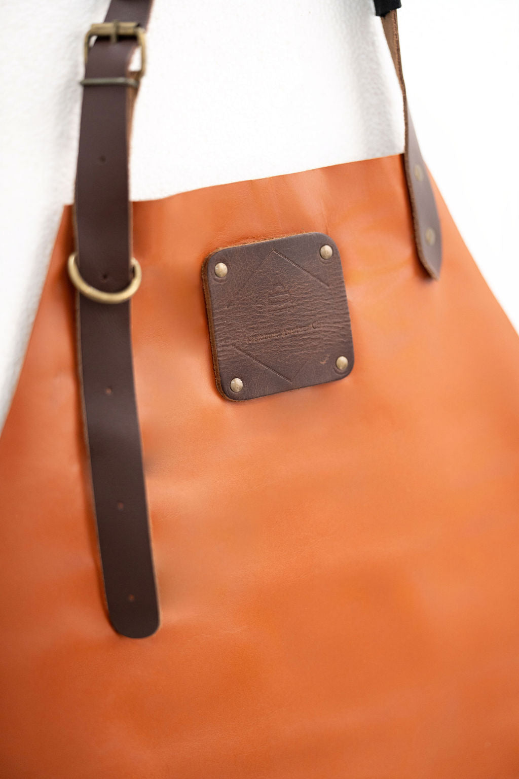 Professional cognac leather apron worn by craftsman in workshop
