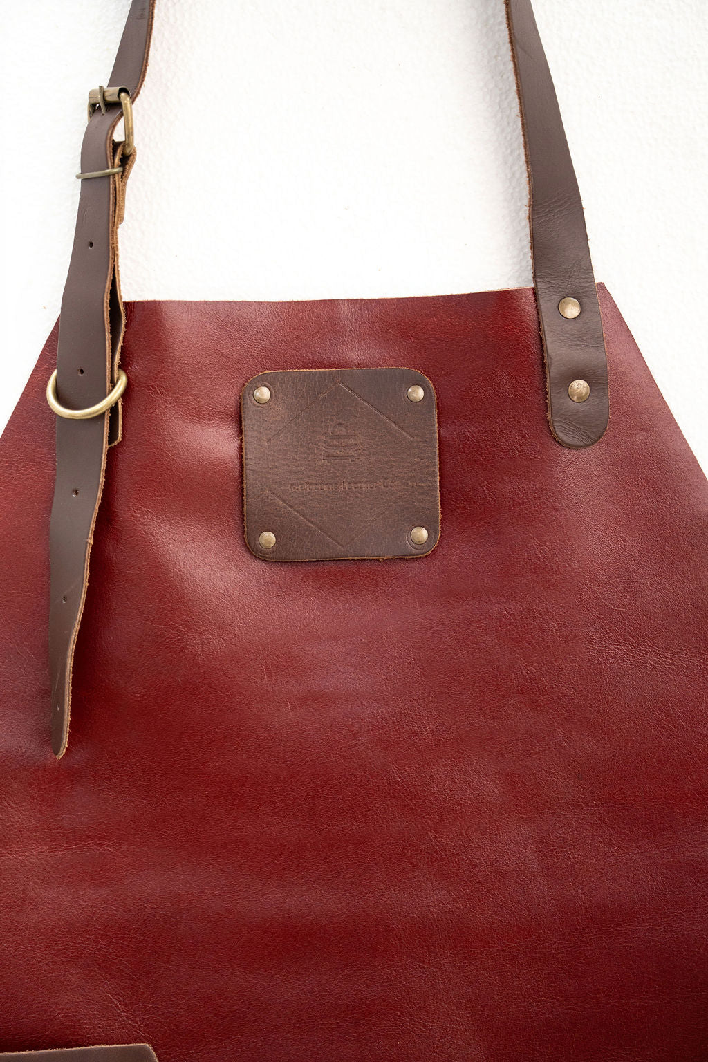 Back view of red leather apron with adjustable straps