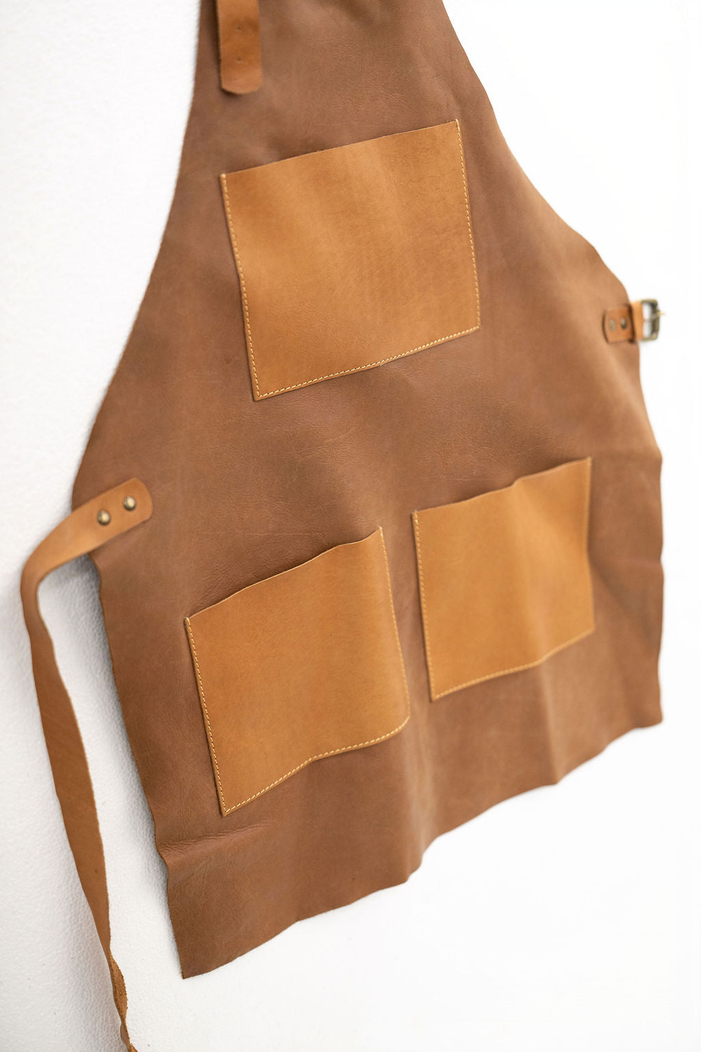 Back view of compact tan leather apron with adjustable straps