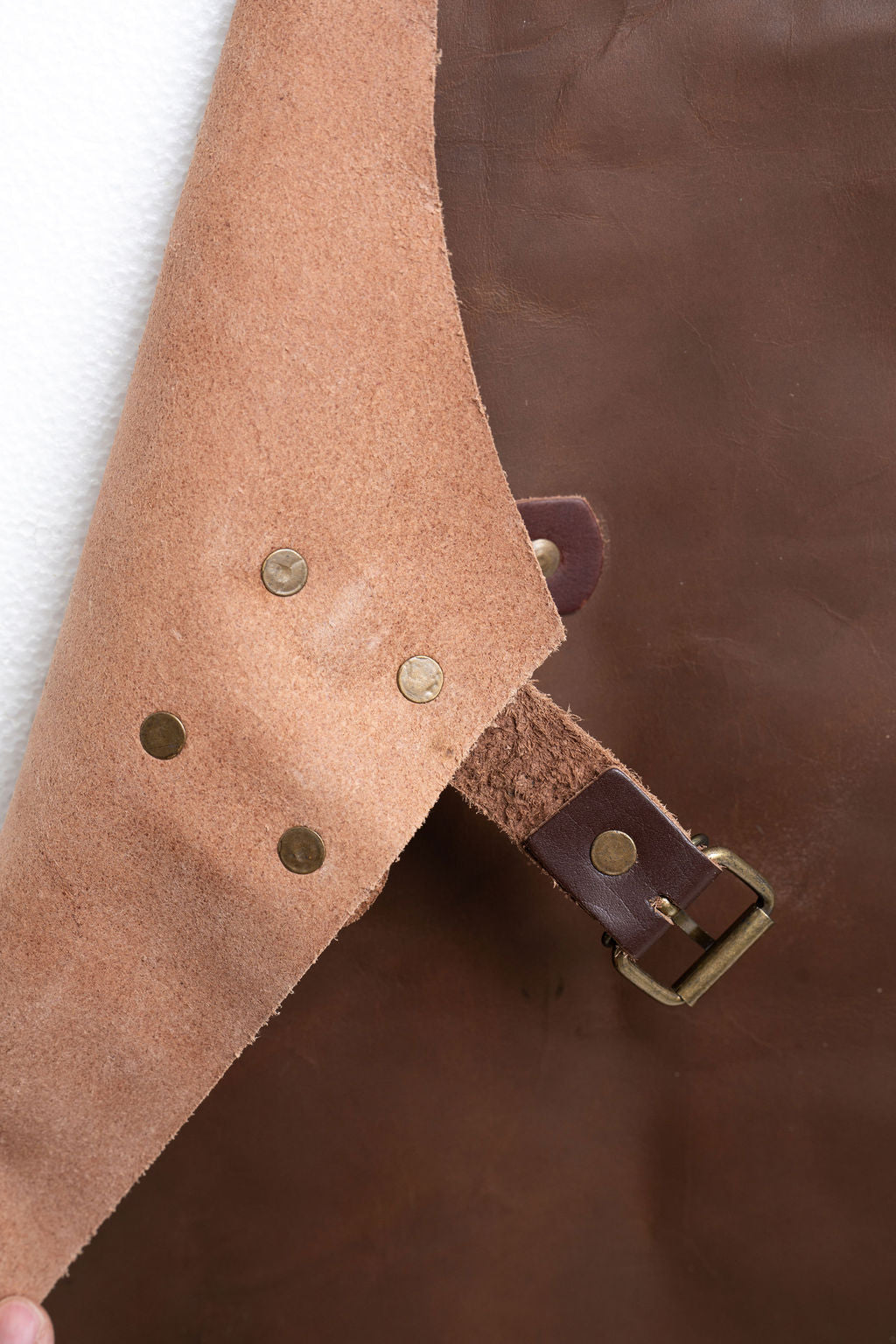 Brown leather apron worn by chef in kitchen workspace
