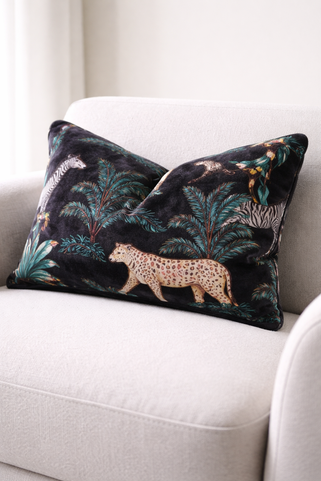 Black safari jungle velvet lumbar cushion cover with leopard zebra and palm print on beige sofa