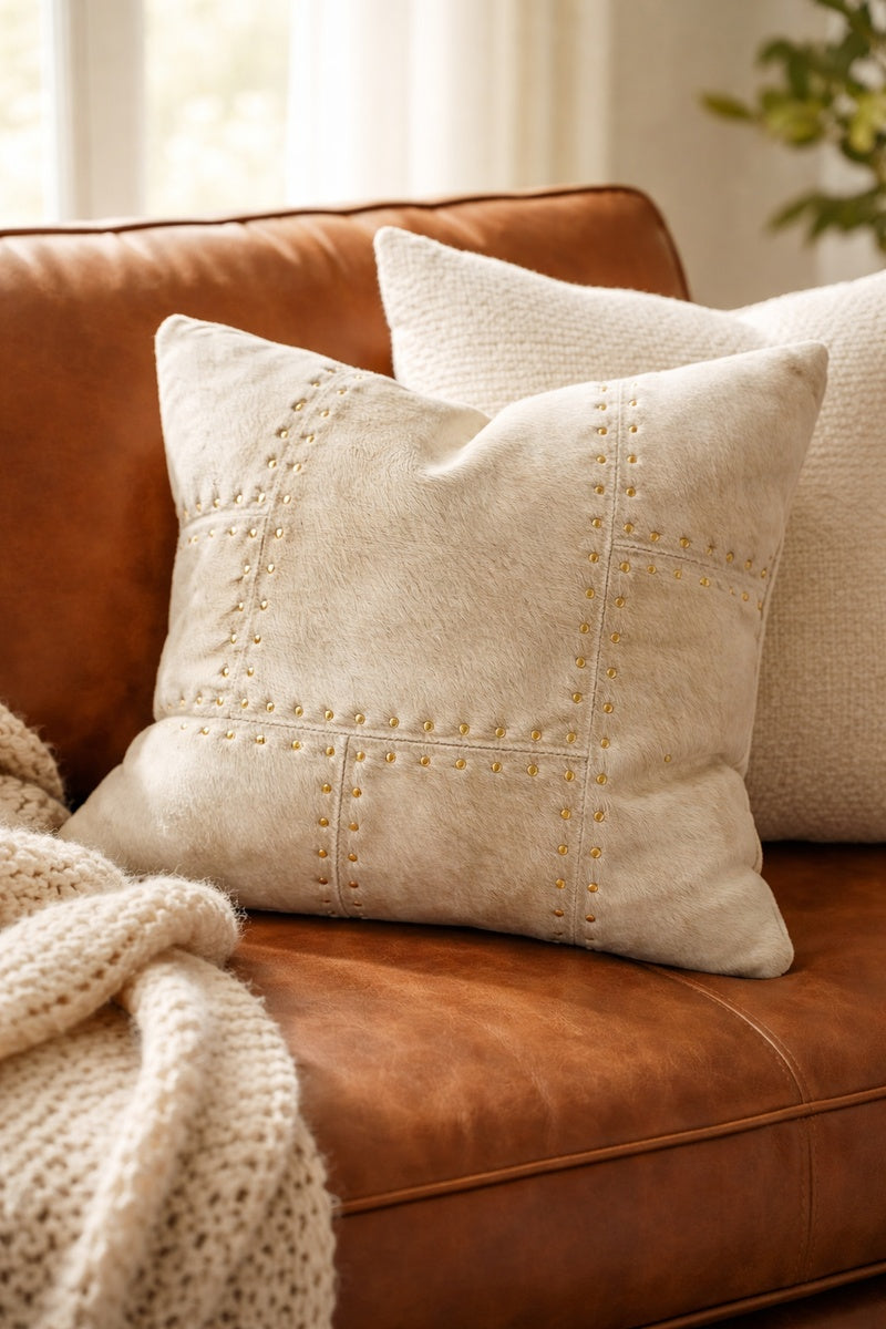 Ivory leather cowhide cushion cover 40x40cm with brass stud detailing on sofa
