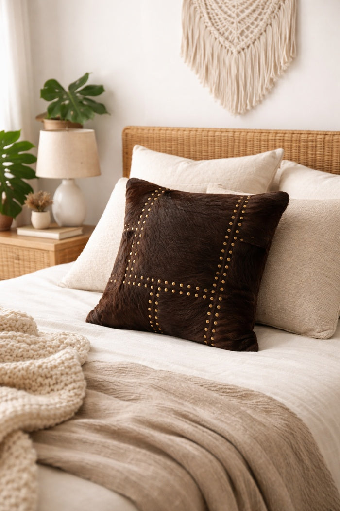Handcrafted studded cowhide leather cushion cover featuring natural hide front and linen fabric back